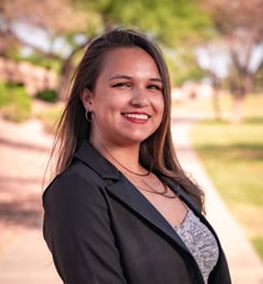 A headshot of Caitlin Mulkey in front of a park