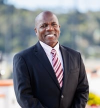 A headshot of Myles Harper in front of a park