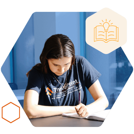 A student sitting at a desk and writing in a notebook-1