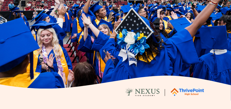 Students in blue cap and gowns celebrating at the graduation ceremony