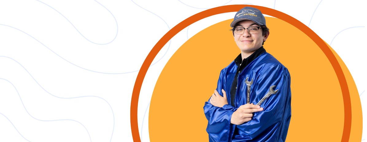 Student in a graduation gown holding tools